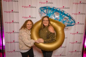 2 women posing with the ring shape ballons